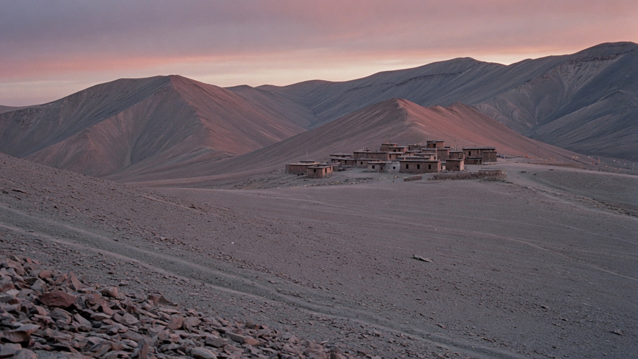 High plateau and distant stone buildings at dusk, documentary landscape